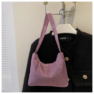 Detail of pink rhinestone shoulder bag with crystal strap against black tweed background