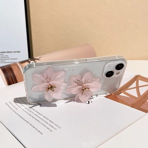 Detail of 3D pink floral decoration with gold center on a clear iPhone 14 protective case