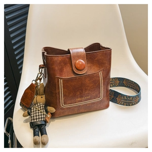 Brown vintage leather bucket bag with gold rivets and bohemian print wide strap