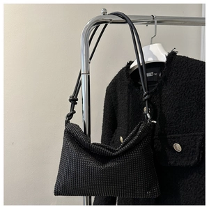 Detailansicht der schwarzen Strasssteine und des geknoteten Lederriemens der Tasche
