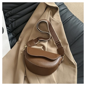 Détail d'un sac besace marron en cuir lisse avec bandoulière tissée réglable