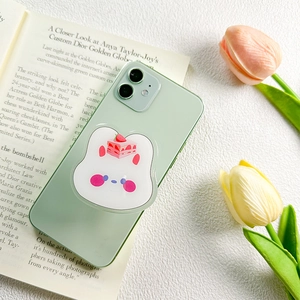 Close-up of cute rabbit phone grip with strawberry cake pattern on a mint green smartphone