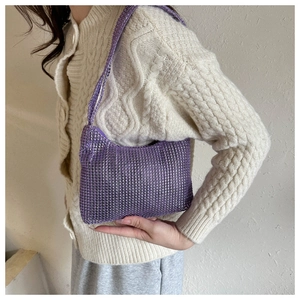 Close-up of purple rhinestone handbag with wide shoulder strap worn with beige knitwear