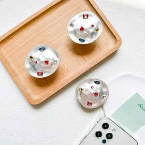 Detail of luxury irregular metal phone grips set with colorful rhinestones and gems
