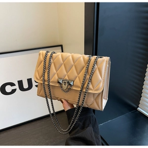 Dettaglio della borsa a tracolla in pelle trapuntata beige con catena e chiusura in metallo