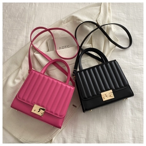 Détail de sacs à main matelassés verticaux fuchsia et noirs avec ferrures dorées et anses