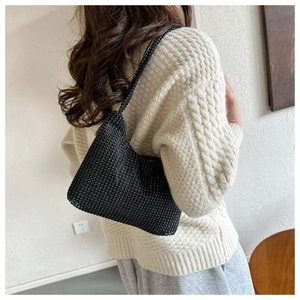 Detail of black rhinestone shoulder bag with shimmering sequins on model for party style