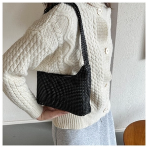 Close-up of black rhinestone hobo bag on shoulder showing sparkling texture