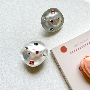 Detailed view of matte silver abstract earrings with colorful crystal heart and star studs