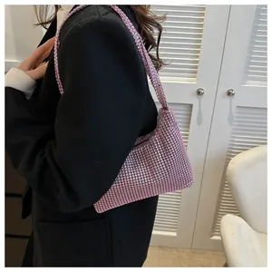 Detail view of pink rhinestone hobo bag on model in a stylish black suit jacket