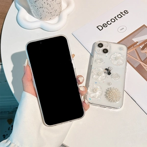 Detail of transparent iPhone case with 3D white resin flowers and pearl decorations