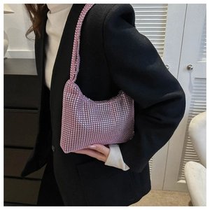Detail shot of shimmering pink rhinestone hobo bag on shoulder for party