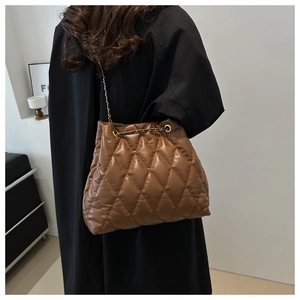 Close-up of brown quilted leather bucket bag with metallic chain and drawstring detail
