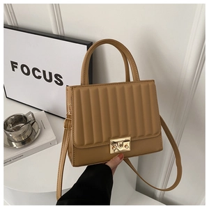 Détail du sac bandoulière marron clair avec texture plissée et fermoir tournant doré