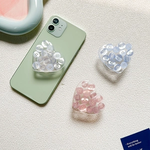 Macro detail of heart-shaped phone grips with button fill on a green smartphone