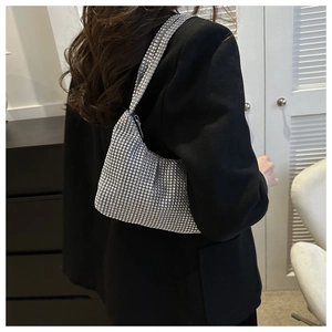 Detail showing the shiny rhinestone mesh surface of the silver hobo bag on black suit