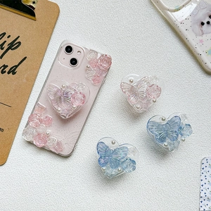 Detail of 3D resin roses, butterflies, and pearls on heart-shaped phone grips