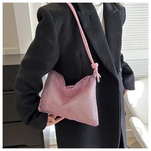 Detail einer rosa Strass-Handtasche mit geknotetem Lederriemen über der Schulter getragen