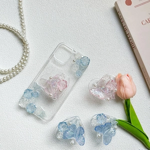Detailed close-up of clear phone case with 3D resin roses, butterflies and pearl hearts