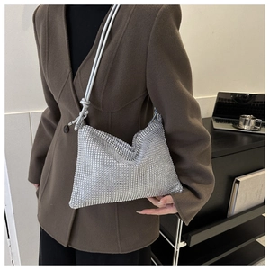 Details der silbernen Strass-Schultertasche mit eleganter Faltenstruktur und Riemen