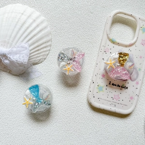 Macro detail of mermaid starfish glitter phone grip and shell phone case decoration