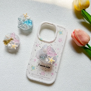 Detail of mermaid tail phone socket with star and seashell motifs in glitter resin