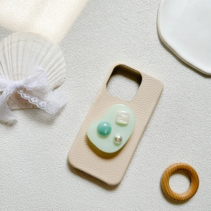Detail of lychee pattern beige phone case with luxury pearl and resin decorations