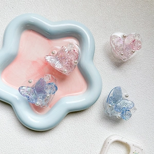 Macro shot of heart-shaped phone grips with 3D resin butterflies and pearls