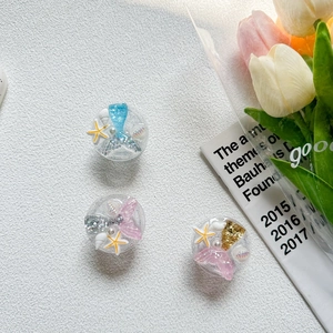 Detailed close-up of glittery mermaid tail and seashell resin phone socket decorations