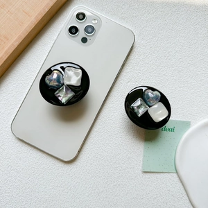 Luxe black heart and geometric gem collapsible phone grip stand on a white mobile device