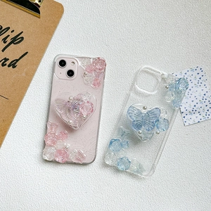 Close-up of 3D rose and butterfly decorations with heart grip on pastel phone cases