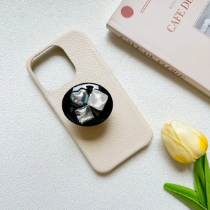 Detailed view of luxury cream faux leather phone case with heart and square gem grip
