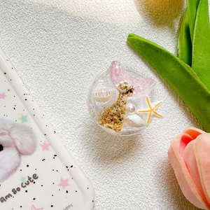 Detail of glitter mermaid tail and shell design on circular phone grip socket