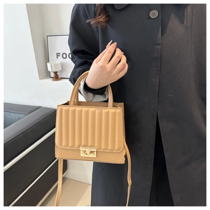 Détail du sac bandoulière camel avec texture plissée et boucle en métal doré
