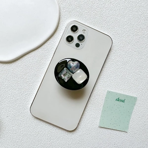 Black resin phone socket with heart and square crystal gems on a white smartphone
