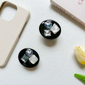 Detail showing two luxury heart and square gemstone phone sockets on a leather phone case