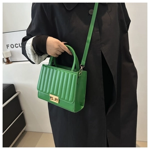 Détail du sac bandoulière plissé vert avec fermoir doré et texture en cuir élégante