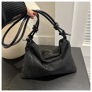 Schicke schwarze Handtasche mit glitzernden Strasssteinen und geknoteten Trägern