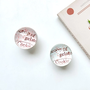 Detail of round transparent glass phone socket with Scoop of gelato Cookie text design
