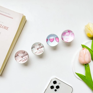 Close-up of four glass phone grips with gelato cookie text and heart patterns