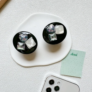 Detailed view of heart and square pearlescent inlays on a black round phone grip