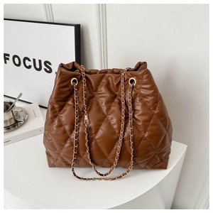 Close-up of brown quilted tote bag with gold chain strap and detailed stitching