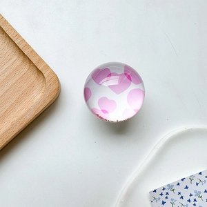 Close-up of glass phone grip with pink hearts and Always love text on wood tray