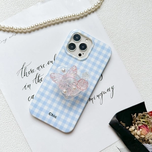 Detailed view of a blue gingham phone case featuring a floral butterfly heart phone grip