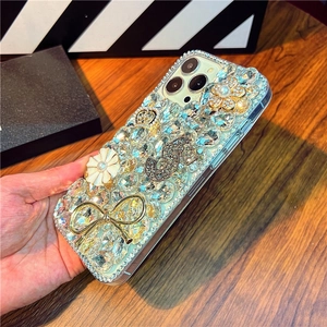 Detailed close-up of luxury iPhone case with rhinestones, metal bow and camellia flower