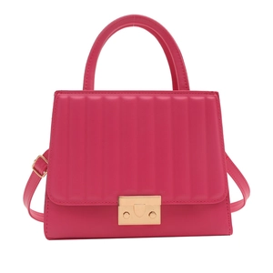 Sac à main matelassé magenta avec fermoir doré et poignée sur fond blanc pur