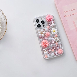 Vue détaillée d'une coque iPhone avec roses 3D, marguerites blanches et perles chic