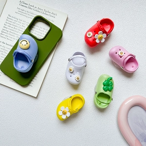 Flat lay of colorful mini clog phone grips with flower and smiley face charms