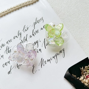 Detail of heart-shaped resin phone grips with 3D rose, butterfly, and pearl accents
