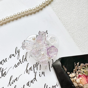 Detailed macro of heart-shaped phone grip with resin butterfly, roses, and pearls